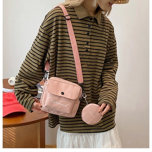 Detailed shot of pink canvas crossbody bag with detachable round coin purse set