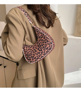 Close-up of leopard print crescent bag on a model wearing a beige khaki blazer