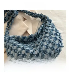Detailed macro view of denim blue and white checkered fabric with frayed edge textures