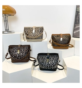 Four leopard print bucket bags in various colors displayed on geometric pedestals
