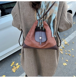Outdoor shot of a vintage brown suede tote bag with contrast leather details and long straps