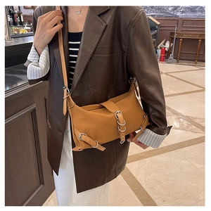Détail du sac à bandoulière marron rétro avec boucle métallique sur tenue de mannequin