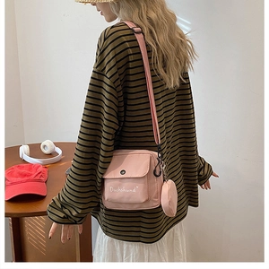 Detail view of pink canvas crossbody bag featuring Dachshund embroidery and round coin pouch