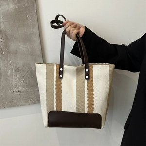 Stylish canvas tote bag with brown leather stripes and shoulder straps for daily commute