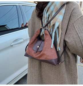 Detail of vintage patchwork tote bag in brown leather and suede texture on model