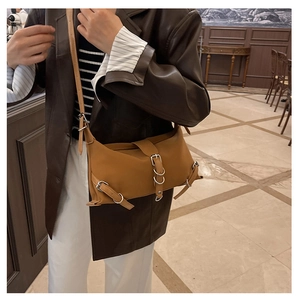 Détail du sac vintage marron avec boucles réglables et texture en cuir synthétique