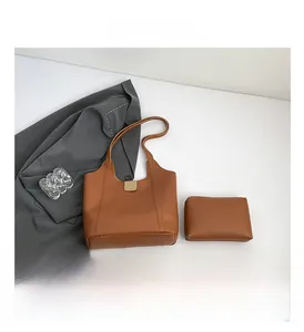 Detailaufnahme der braunen Leder-Tote-Bag mit goldener Schnalle und passendem Etui Set