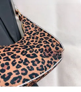 Macro shot of hobo bag featuring leopard print fabric and golden zipper hardware