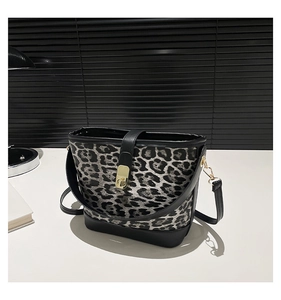 Detailed close-up of leopard print crossbody bucket bag with black leather and gold hardware