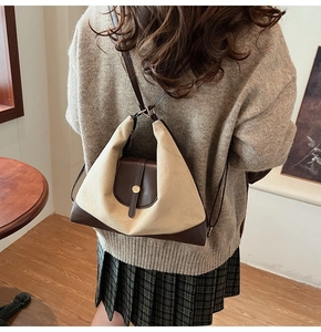 Detail of vintage beige canvas and brown leather stitching on a stylish shoulder tote bag