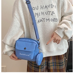 Blue canvas crossbody bag with white Dachshund lettering and round mini coin purse detail