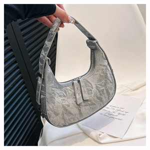 Detail of silver crescent bag featuring unique crinkled paper texture and double zippers