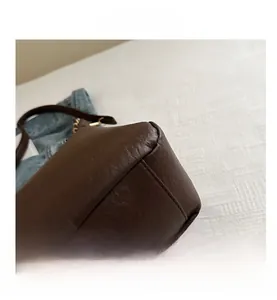 Détail de couture précise et texture raffinée sur un sac cabas en similicuir marron foncé
