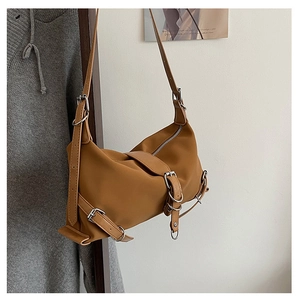 Détail du sac à bandoulière marron vintage avec boucles multiples et garnitures métalliques