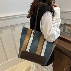 Striped canvas tote bag with brown leather shoulder straps and metal rivet detail