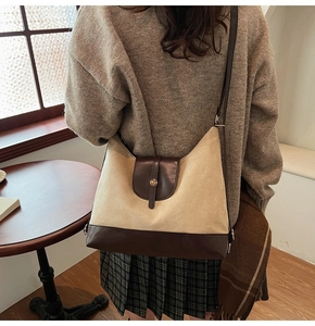 Detail view of the vintage beige canvas and brown leather shoulder bag with golden buckle