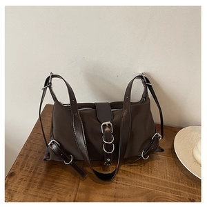 Détail du sac bandoulière rétro marron foncé avec boucles punk et tissu en nylon