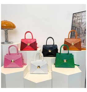 Detail view of colorful envelope handbags with gold pyramid studs and croc-embossed side texture