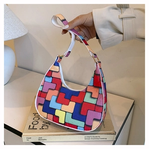 Detail of colorful geometric felt underarm bag with adjustable white shoulder strap