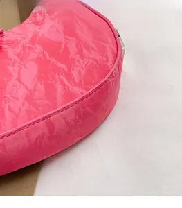 Detailed close-up of bright pink wrinkled patent leather texture and silver buckle