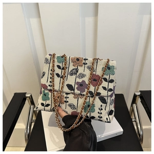 Close-up of vintage floral tapestry crossbody bag with gold chain strap detail