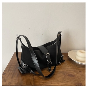 Détail du sac à bandoulière en nylon noir avec boucles argentées et lanières en cuir