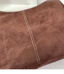 Détail du sac cabas en daim marron avec doubles surpiqûres blanches et fini mat