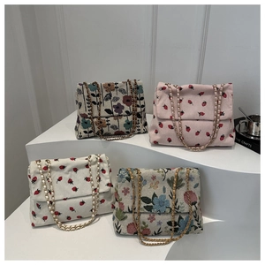 Detail view of corduroy and floral jacquard shoulder bags with elegant chain straps