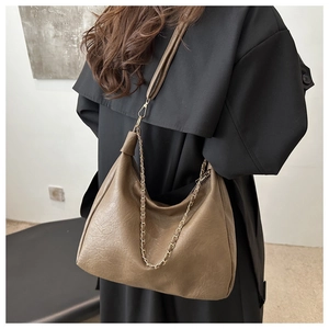 Détail du sac Hobo en cuir marron avec chaîne dorée élégante et bandoulière réglable