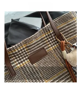 Detail der Houndstooth-Tasche mit hochwertigen Nähten und braunen Ledergriffen