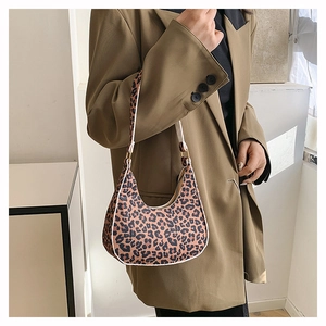 Chic leopard print underarm bag shown on a model in a minimalist modern interior setting