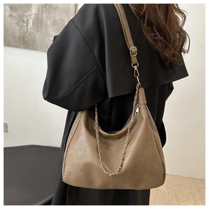 Détail du sac hobo kaki avec texture cuir grainé et décoration de chaîne dorée élégante
