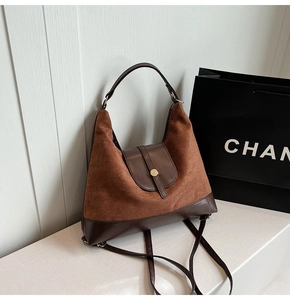 Detailed close-up of brown textured leather hobo bag with distinctive metal buckle design