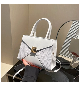 Detail of white crocodile embossed texture and golden square buckle on shoulder bag