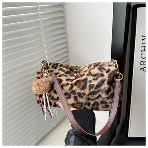 Détail du sac cabas en peluche léopard avec un charm ours et une bandoulière en cuir brun