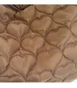 Detail of heart-shaped quilting on brown tote bag fabric with subtle satin finish