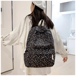 Detail of floral canvas backpack featuring pink and blue flowers and zipper pocket