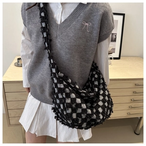 Hobo style black and white checkerboard bag featuring long fringe and crescent shape