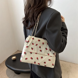 Minimalist beige corduroy crossbody bag with red strawberry embroidery and golden chain strap