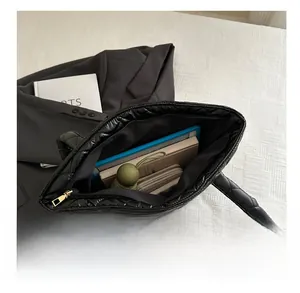 Internal view of black quilted tote bag showing spacious capacity for laptop and books