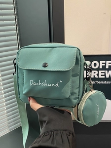 Green canvas crossbody bag with small round coin purse and white dachshund print