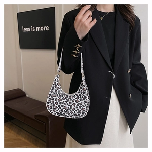 Detailed view of trendy leopard print crescent shoulder bag on a stylish model outfit