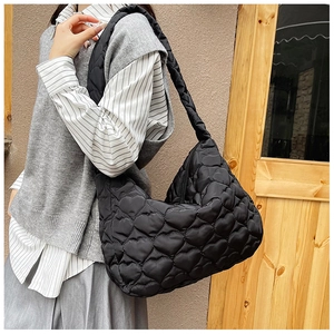 Close-up of black heart quilted tote bag in nylon material with textured stitching
