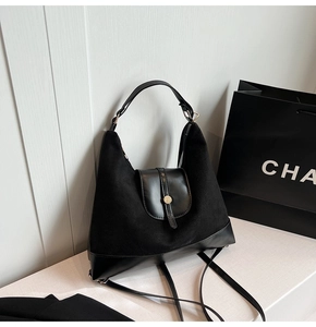Detail of black tote bag showing premium mixed suede textures and gold metal lock hardware