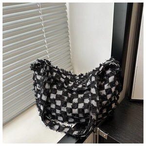 Detail of black and white checkerboard canvas bag showing frayed edges and thick texture