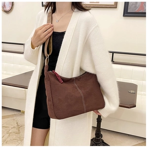 Détail du sac bandoulière marron en demi-lune avec coutures contrastées blanches et zip