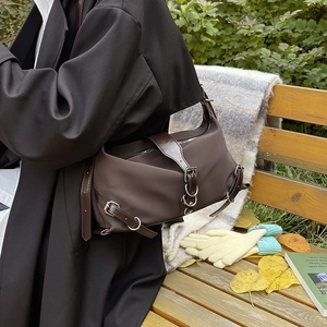 Sac Boston marron foncé vintage avec garniture en cuir sur banc de parc d'automne
