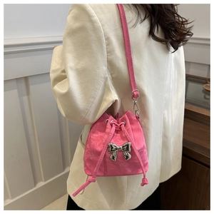 Pink drawstring bucket bag with silver metal bow and pleated texture on model