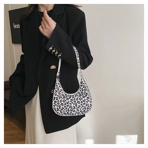 Detail view of stylish leopard print hobo underarm bag with zipper closure on model