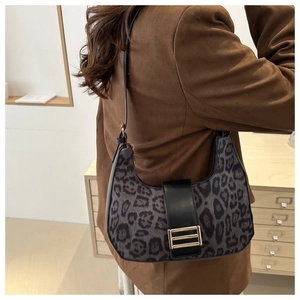 Dettaglio della borsa hobo leopardata con tracolla in pelle e fibbia dorata su modella